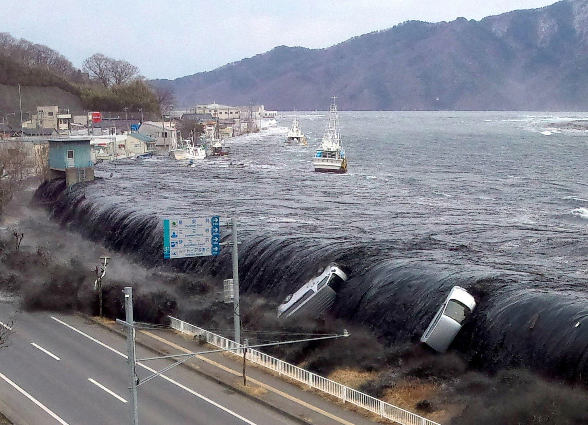 The tsunami breeches an embankment, with water flowing into the city of Miyako in Iwate prefecture, Japan, March 11, 2011. /VCG