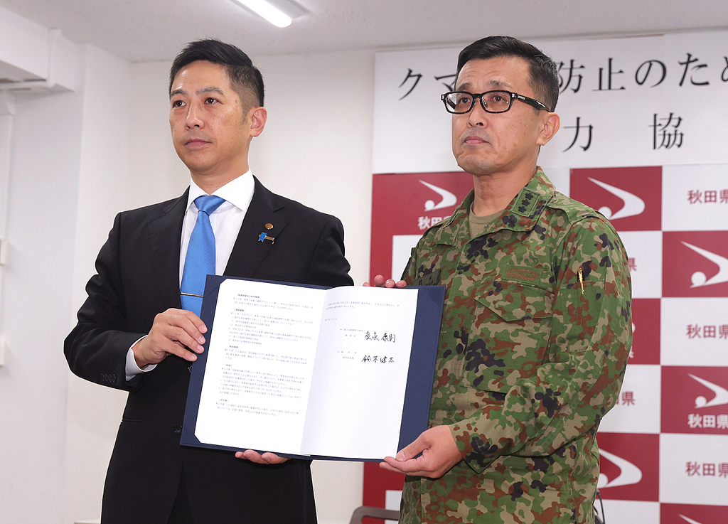Akita Prefecture Governor Kenta Suzuki and Commander-in-Chief of the 9th Division of the Japan Ground Self-Defense Force, Yasunori Matsunaga, attend the signing ceremony of a cooperation agreement on preventing bear attacks on November 5, 2025. /CFP