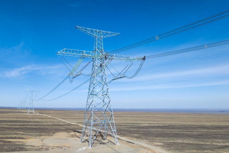 Staff members check the transmission lines of an ultra-high voltage direct current transmission project in Xinjiang Uygur Autonomous Region in northwest China, linking with Chongqing in the southwest China, April 24, 2025. /Xinhua