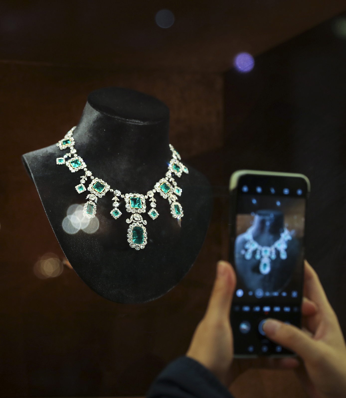 A visitor takes photos of a necklace from V Muse's collection at the 8th China International Import Expo in Shanghai on November 8, 2025. /VCG