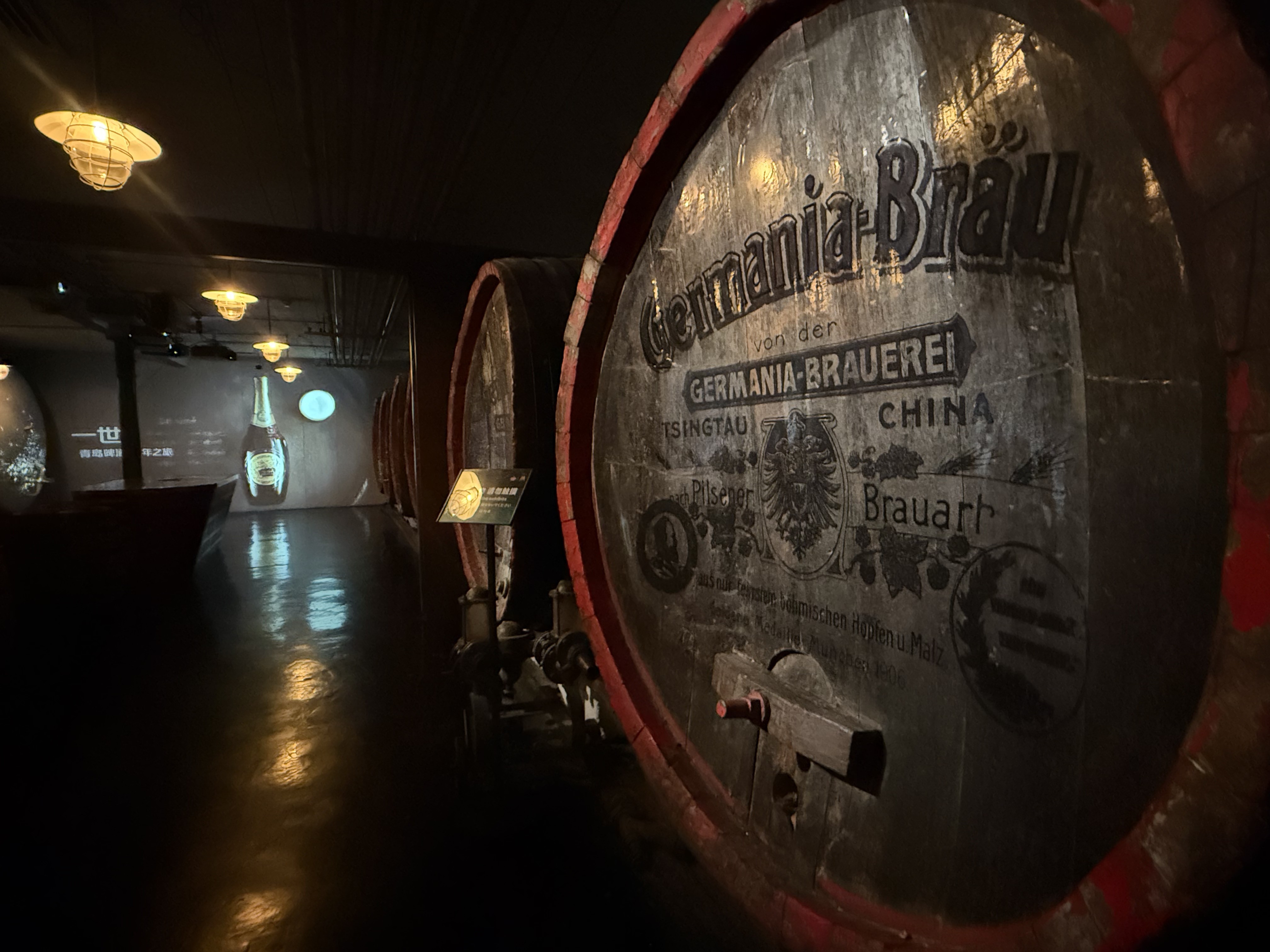 Rows of large wooden beer barrels rest in the dimly lit cellar of the Tsingtao Beer Museum, Qingdao, September 2025, Zaruhi Poghosyan. /CGTN