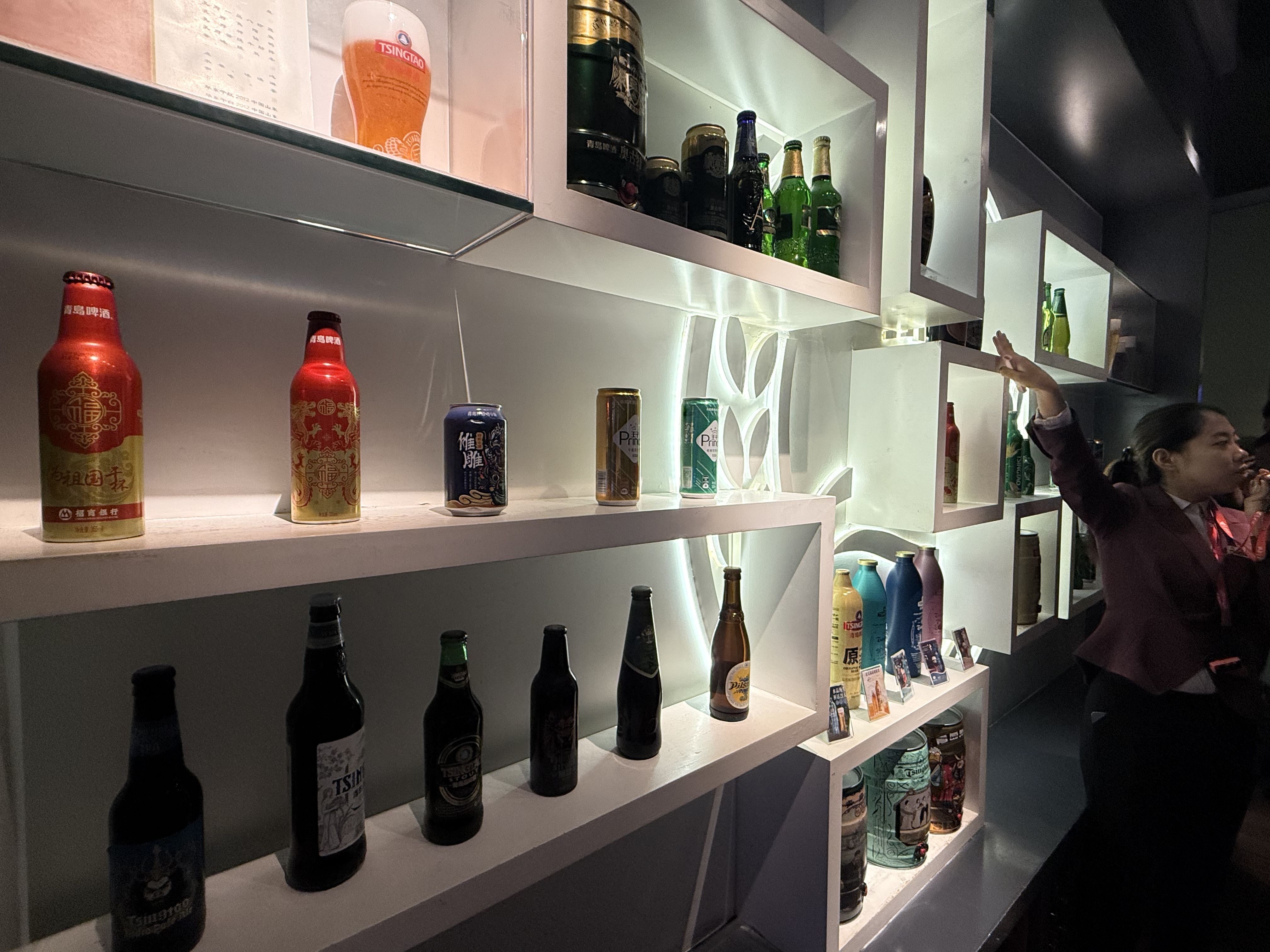 A wall of vintage Tsingtao beer bottles showcases evolving label designs from different eras, Tsingtao Beer Museum, Qingdao, September 2025, Zaruhi Poghosyan. /CGTN