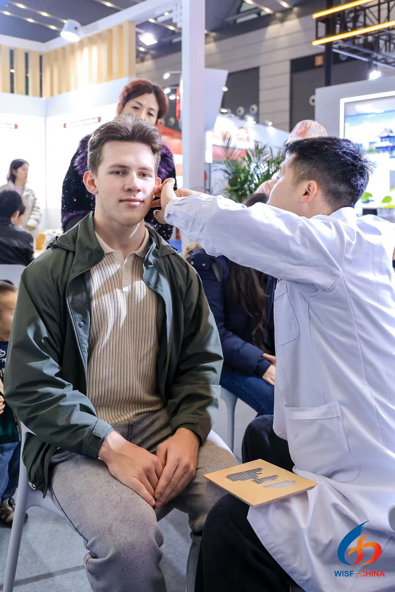 A visitor experiences an authentic TCM treatment at the 6th Western International Sourcing Exhibition in Xi'an in November 2025. /Photo provided to CGTN