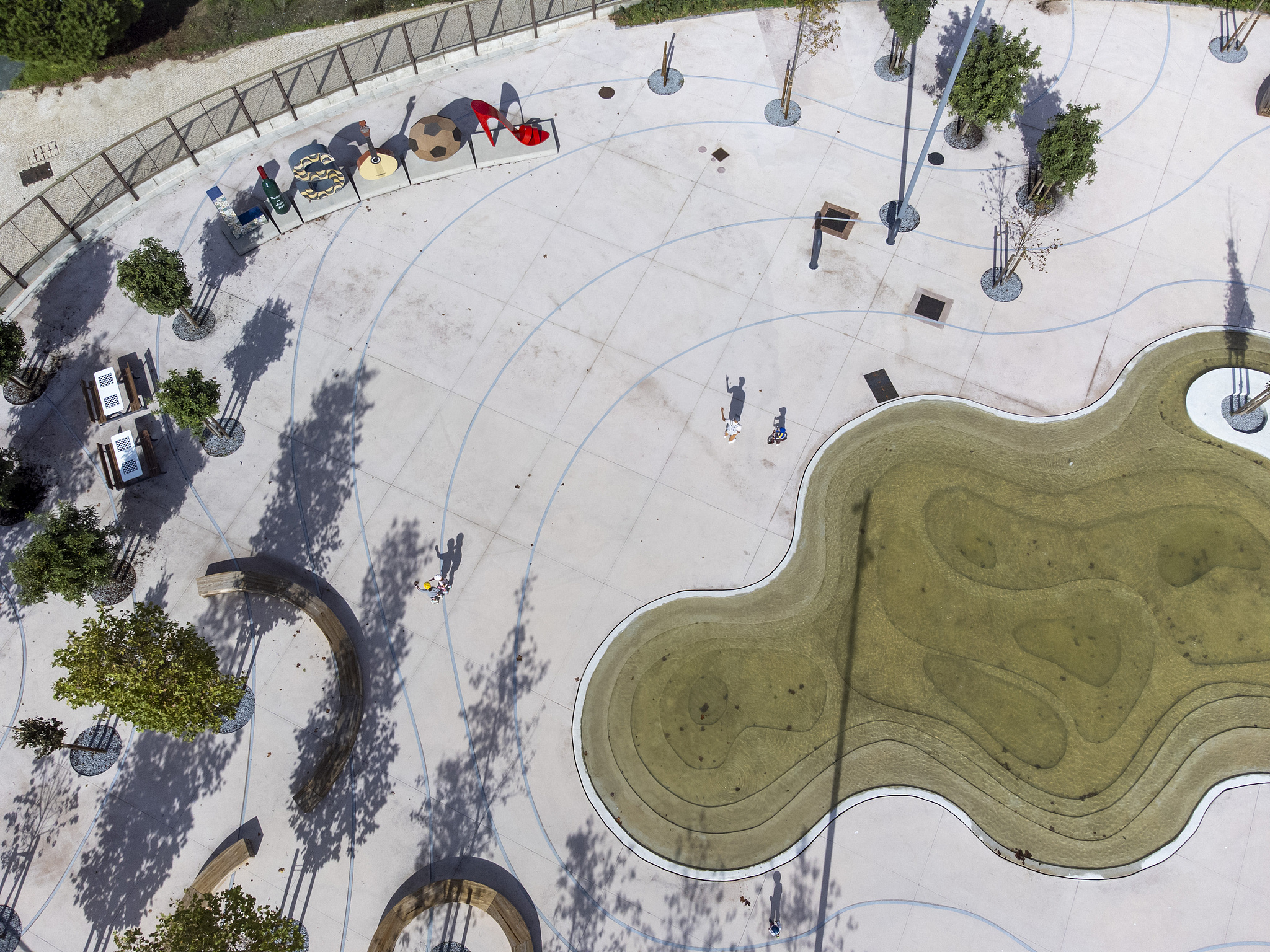 An aerial view shows people in a park in Lisbon, Portugal, November 2, 2025. As temperatures rise and heatwaves become more frequent, Lisbon invests in expanding green infrastructure to mitigate the effects of climate change. Urban parks and green corridors play a crucial role in cooling the city, improving air quality, and enhancing resilience to environmental challenges. /VCG
