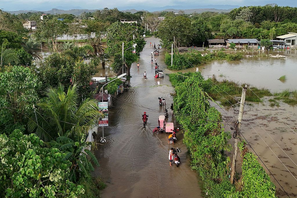 People wade through flooded streets as heavy rains brought by Super Typhoon Fung-wong continued to inundate homes in Tuguegarao City, Cagayan province, north of Manila, Philippines, November 11, 2025. /CFP
