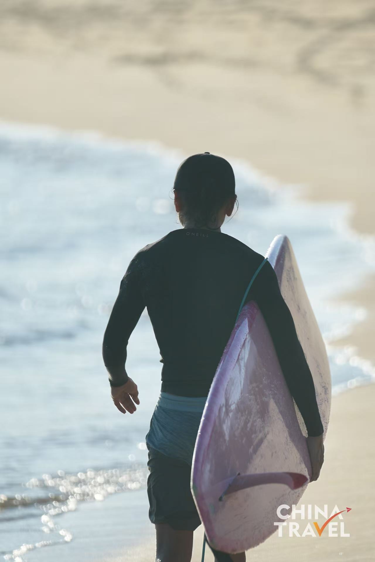 Surfers are seen at Riyue Bay in Wanning, Hainan. /CGTN
