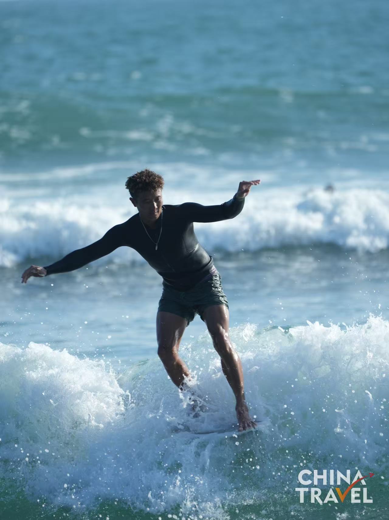 Surfers are seen at Riyue Bay in Wanning, Hainan. /CGTN

