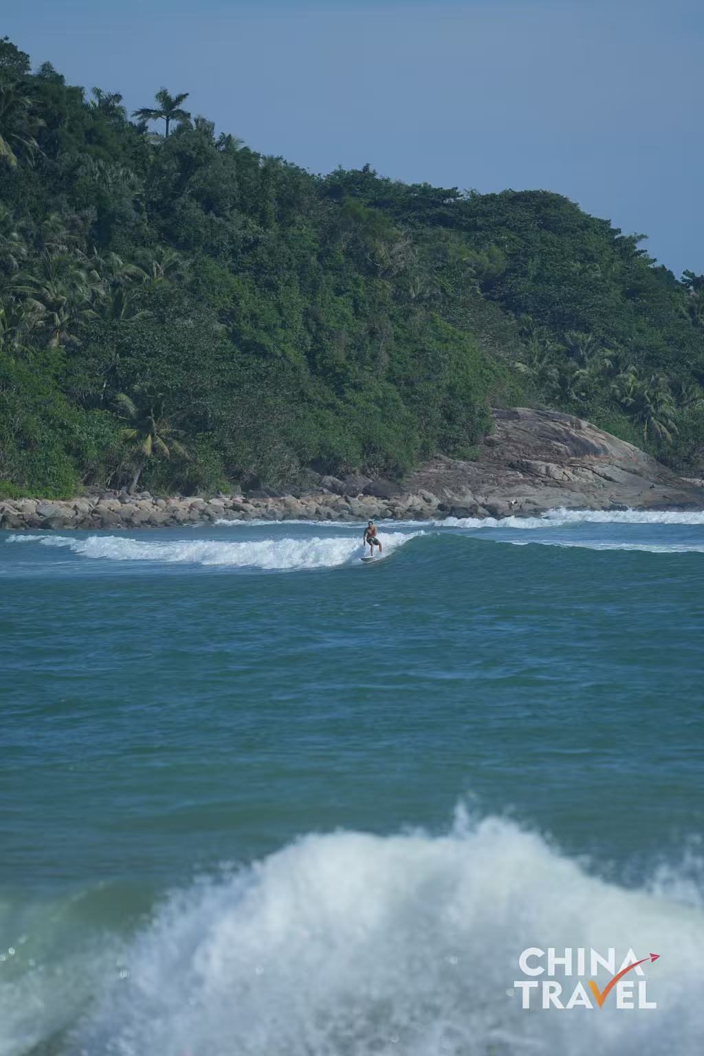 Surfers are seen at Riyue Bay in Wanning, Hainan. /CGTN
