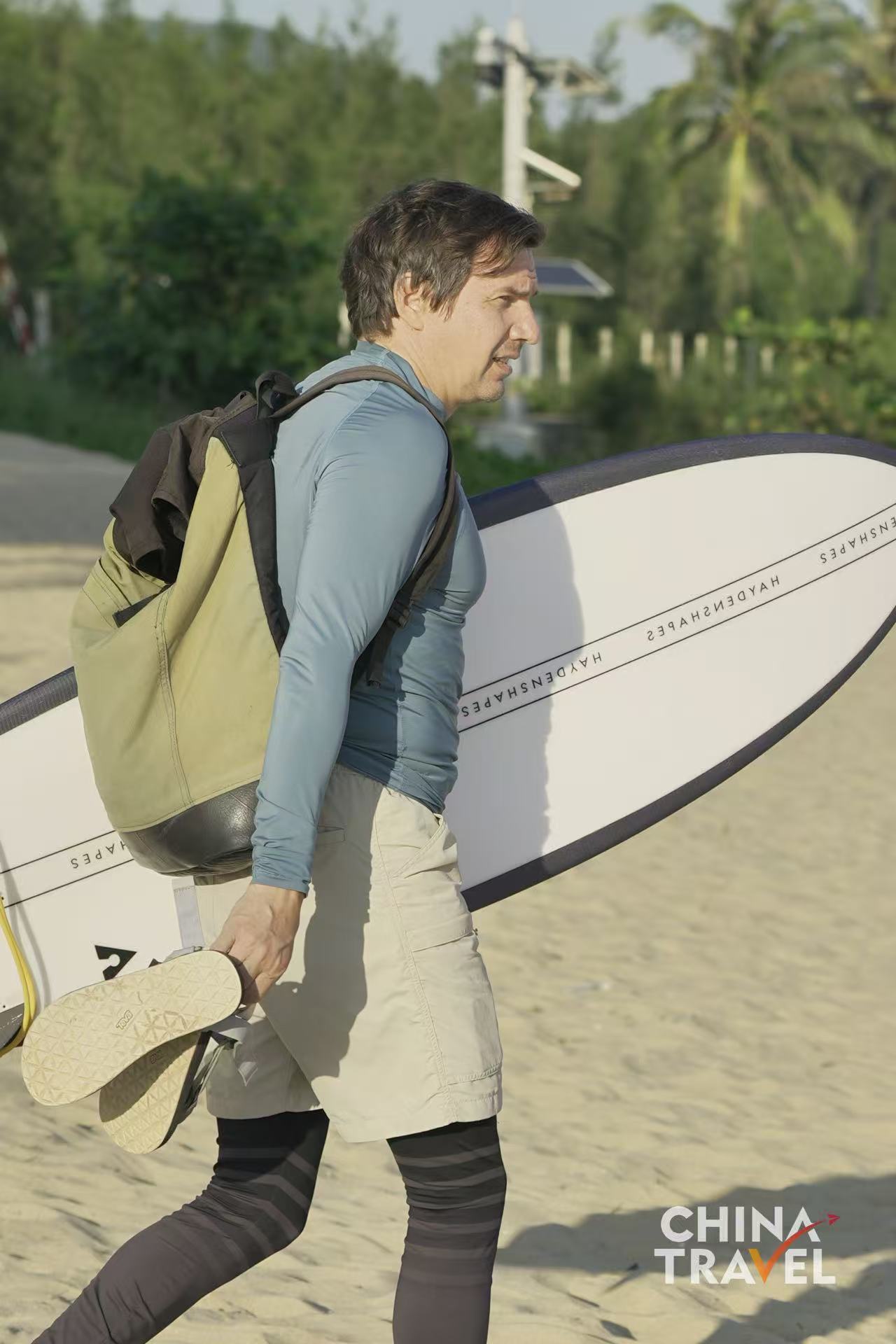 Surfers are seen at Riyue Bay in Wanning, Hainan. /CGTN
