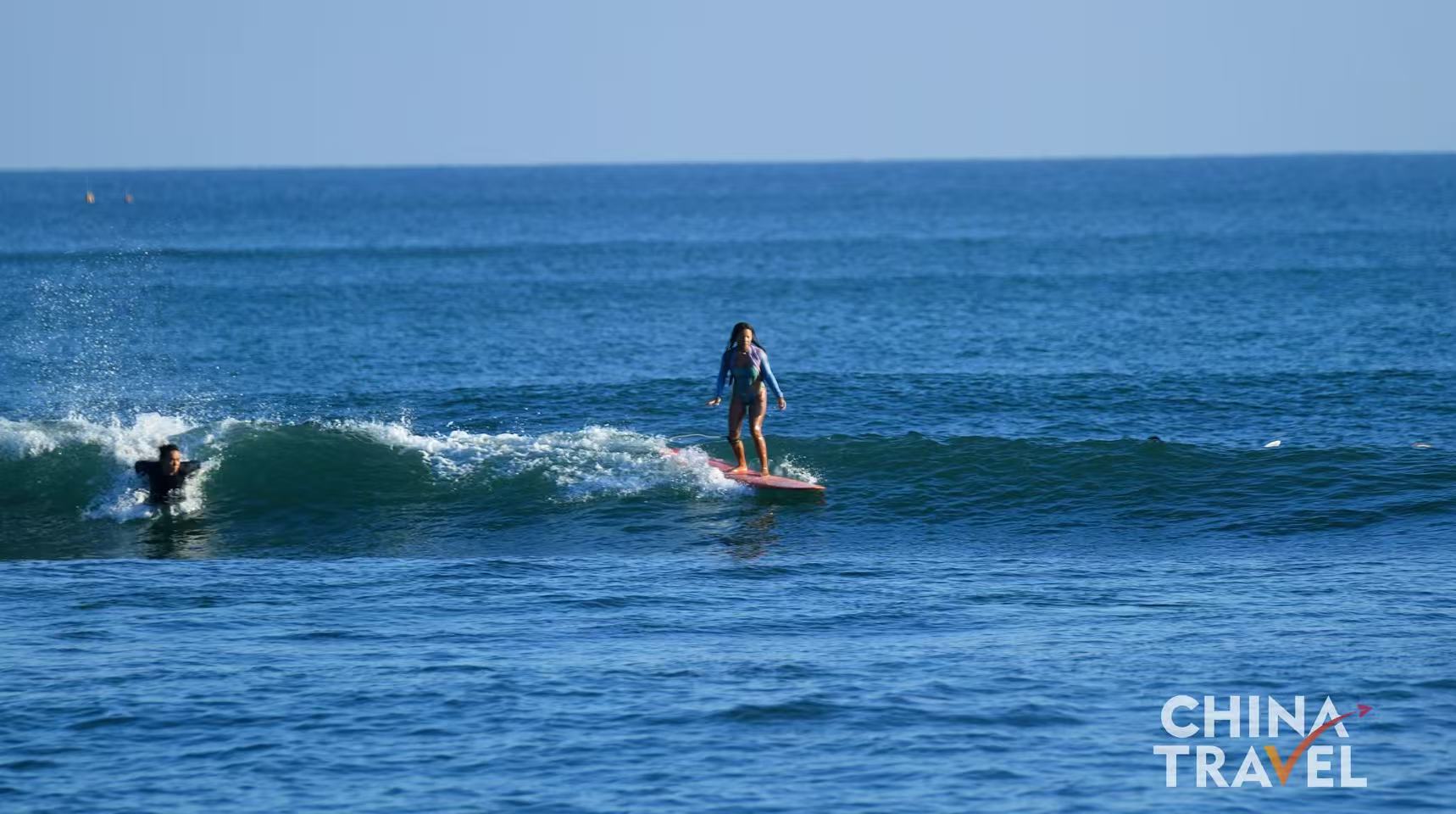 Surfers are seen at Riyue Bay in Wanning, Hainan. /CGTN

