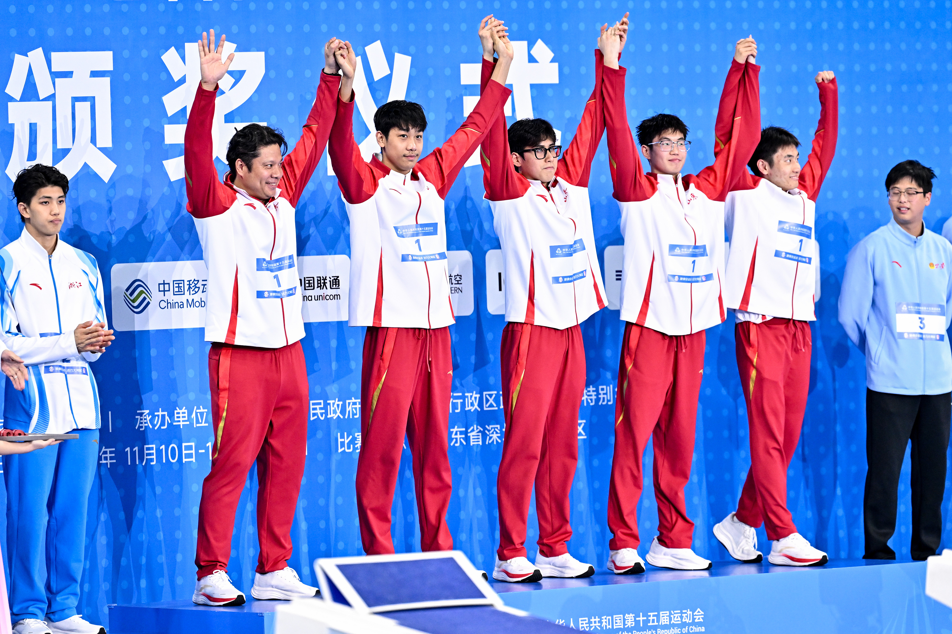 Shandong's swimmers celebrate on the podium after winning the men's 4×200-meter freestyle relay final at China's 15th National Games in Shenzhen, November 15, 2025. /VCG