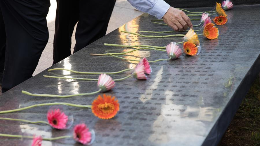 A person lays a flower in front of the monument marking the victory in the Chinese People's War of Resistance Against Japanese Aggression and Taiwan's recovery from Japanese occupation during a commemorative event in Taipei, China's Taiwan region, October 25, 2020. /Xinhua
