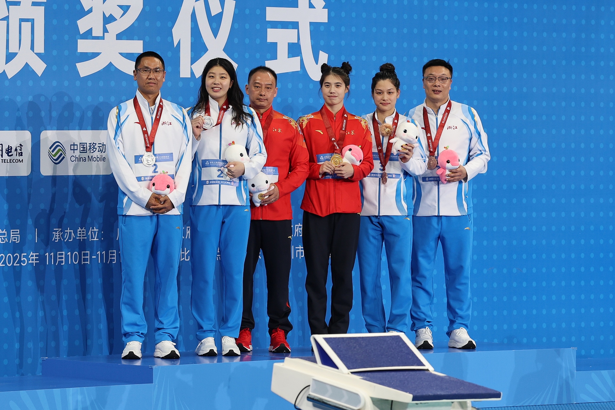 Jiangsu's Zhang Yufei (R3) celebrates during the awards ceremony after winning the women's 50-meter butterfly final at China's 15th National Games in Shenzhen, November 16, 2025. /VCG