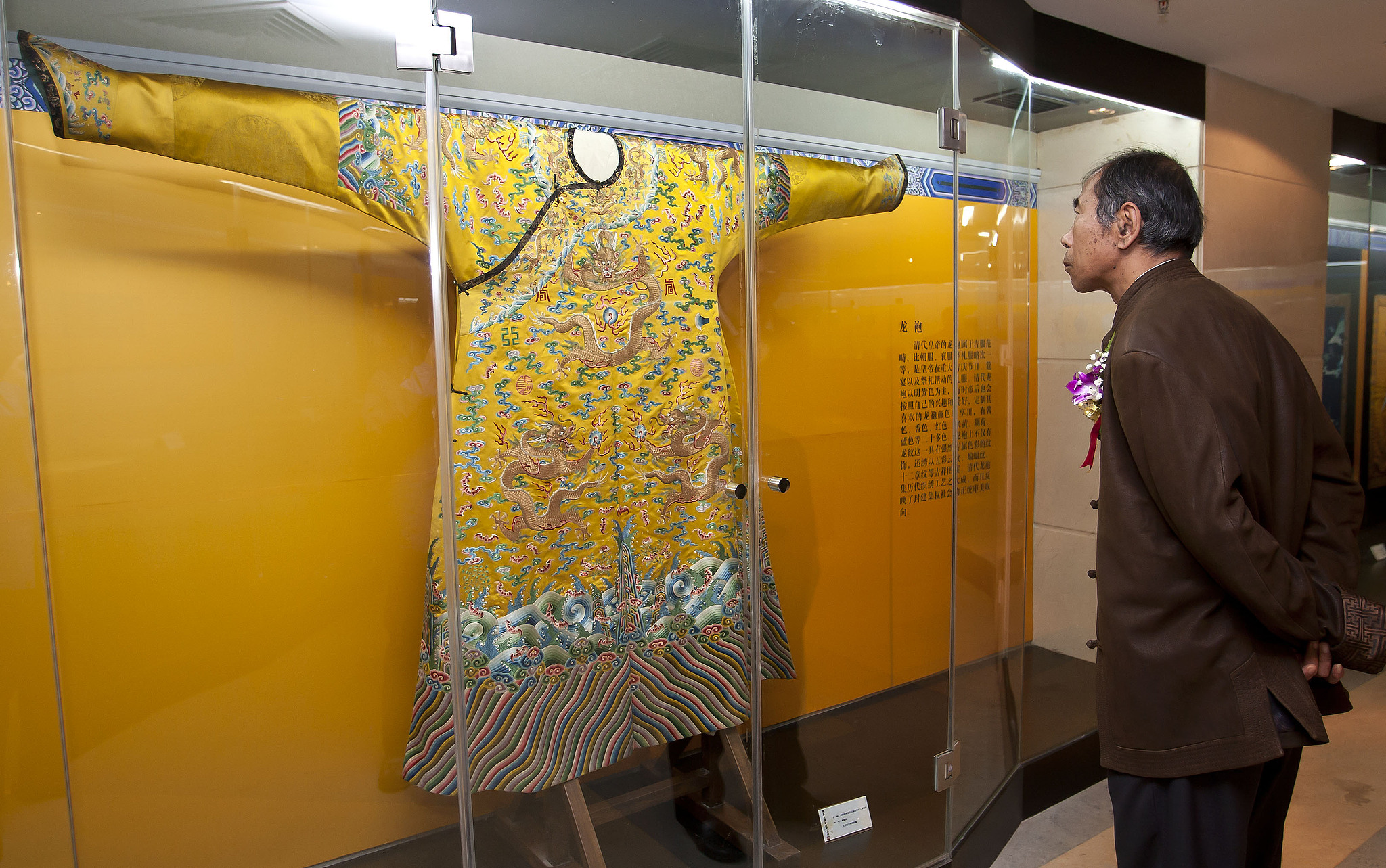 Foto arsip menunjukkan seorang pria mengagumi jubah naga kaisar Dinasti Qing selama pameran di Beijing. /VCG