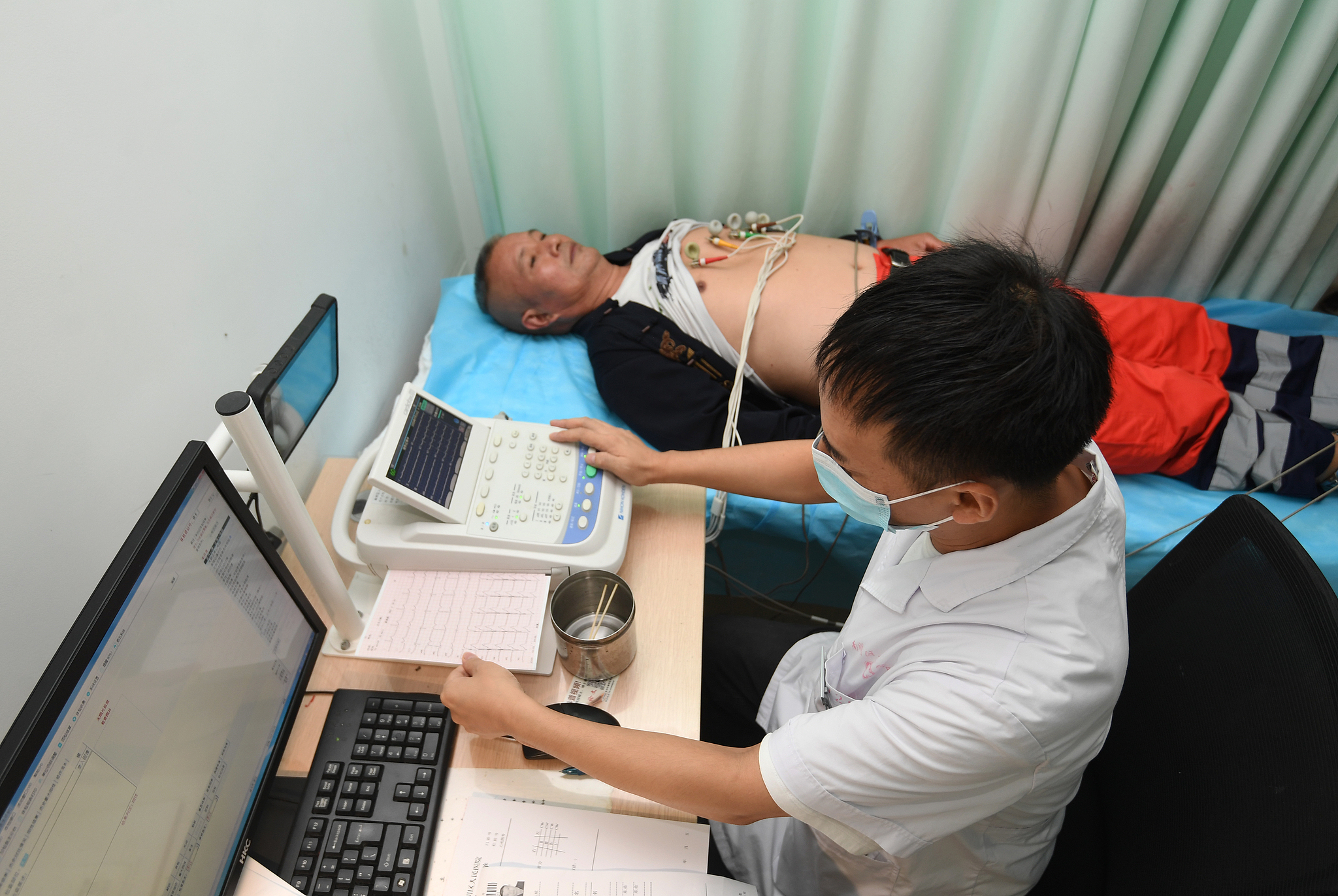 A medical worker conducts electrocardiogram screening for a patient in Guiyang city, Guizhou Province, southwest China, September 26, 2025. /VCG