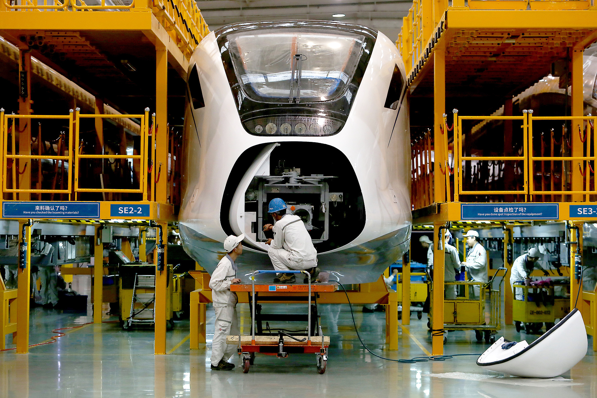 Workers inspecting high-speed trains at the Final Assembly Branch of CRRC Qingdao Sifang in Qingdao, Shandong Province, October 13, 2019. /VCG