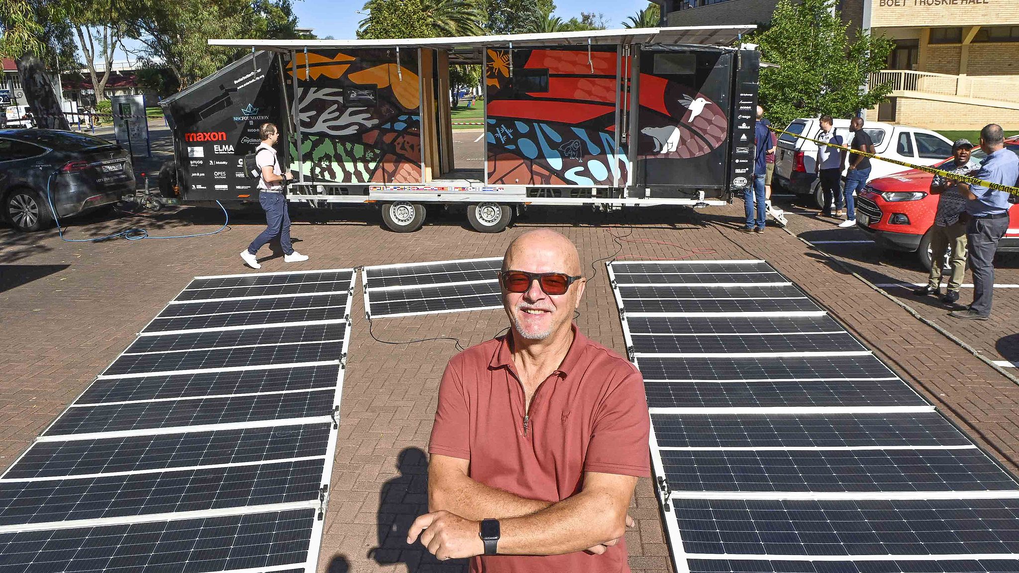 A man poses for a photo with dozens of solar panels being recharged at the Central University of Technology (CUT) during the SolarButterfly world tour in Bloemfontein, South Africa, February 19, 2025. /CFP