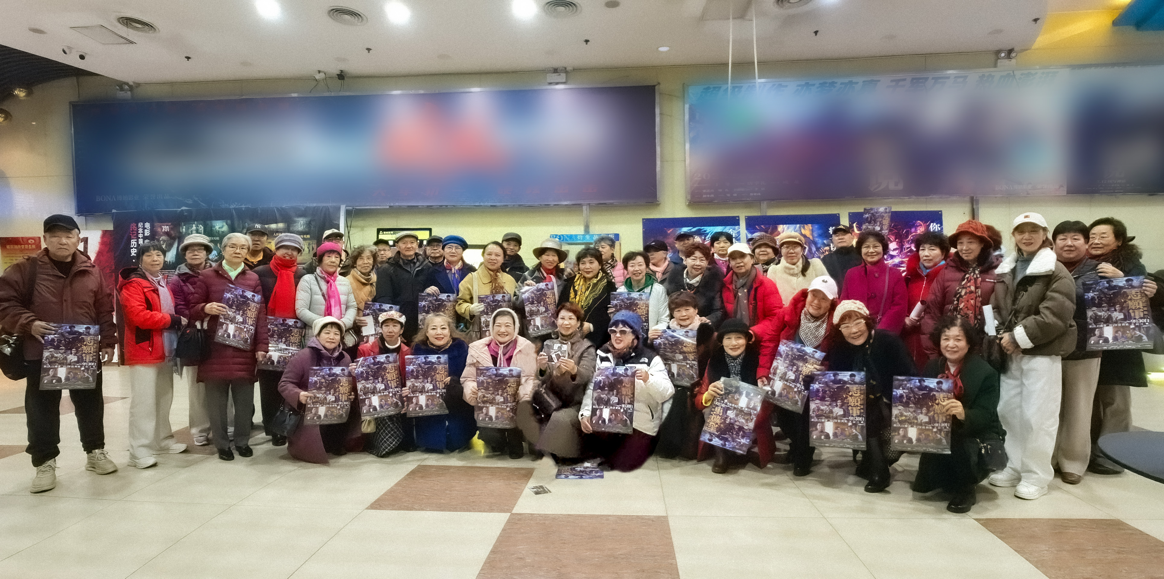 A group of elderly moviegoers pose for a picture together holding movie posters of 