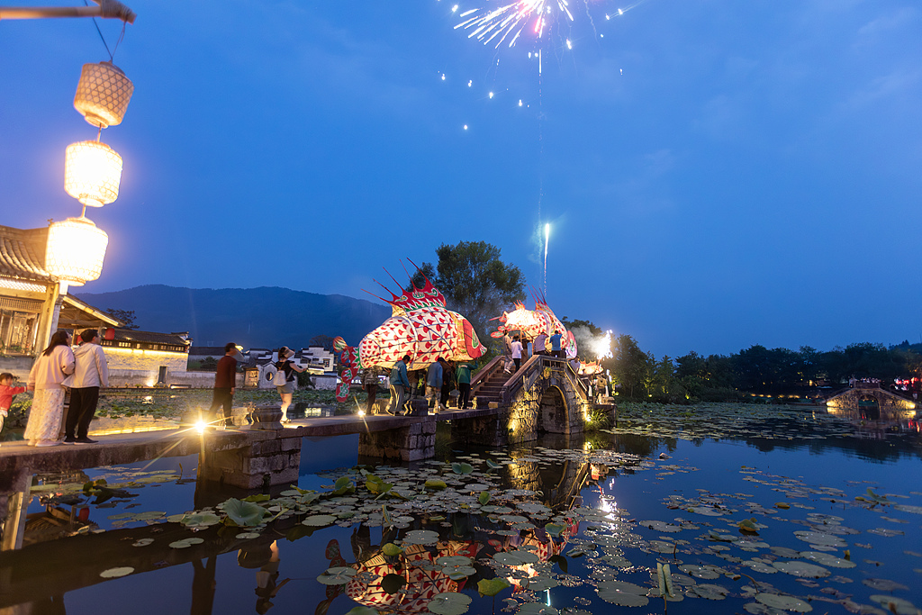 Fish lanterns parade to drum beats while fireworks bloom in the evening sky above Chengkan Village in Huizhou District of Huangshan, Anhui on May 24, 2025. /VCG