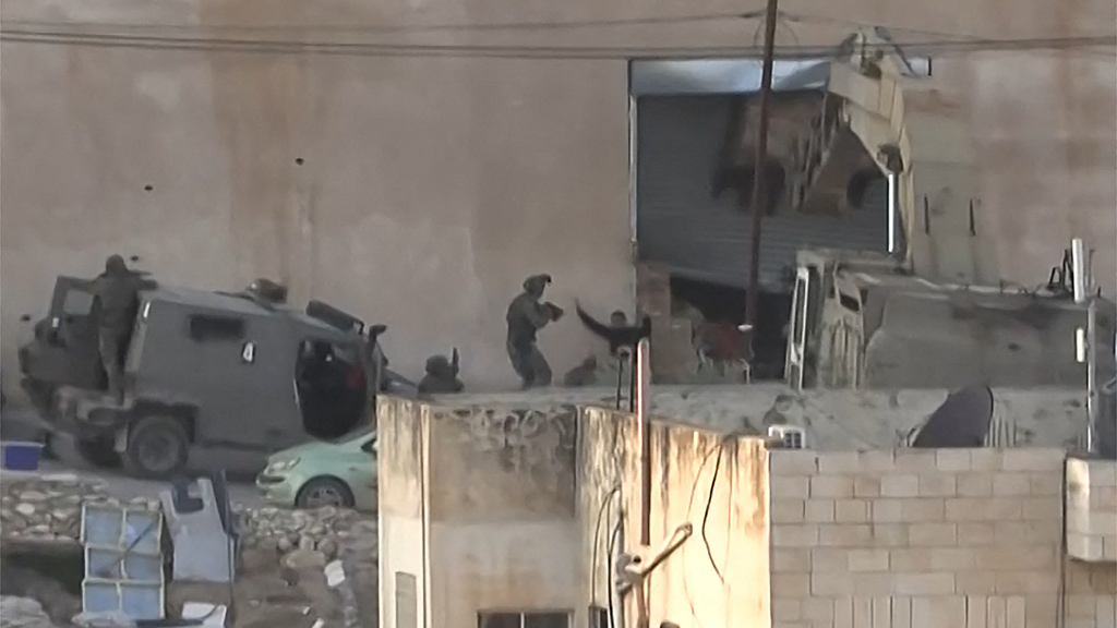 This image shows two Palestinian men kneeling on the ground to Israeli forces shortly before they were shot dead during a military operation in Jenin, West Bank, November 27, 2025. /VCG