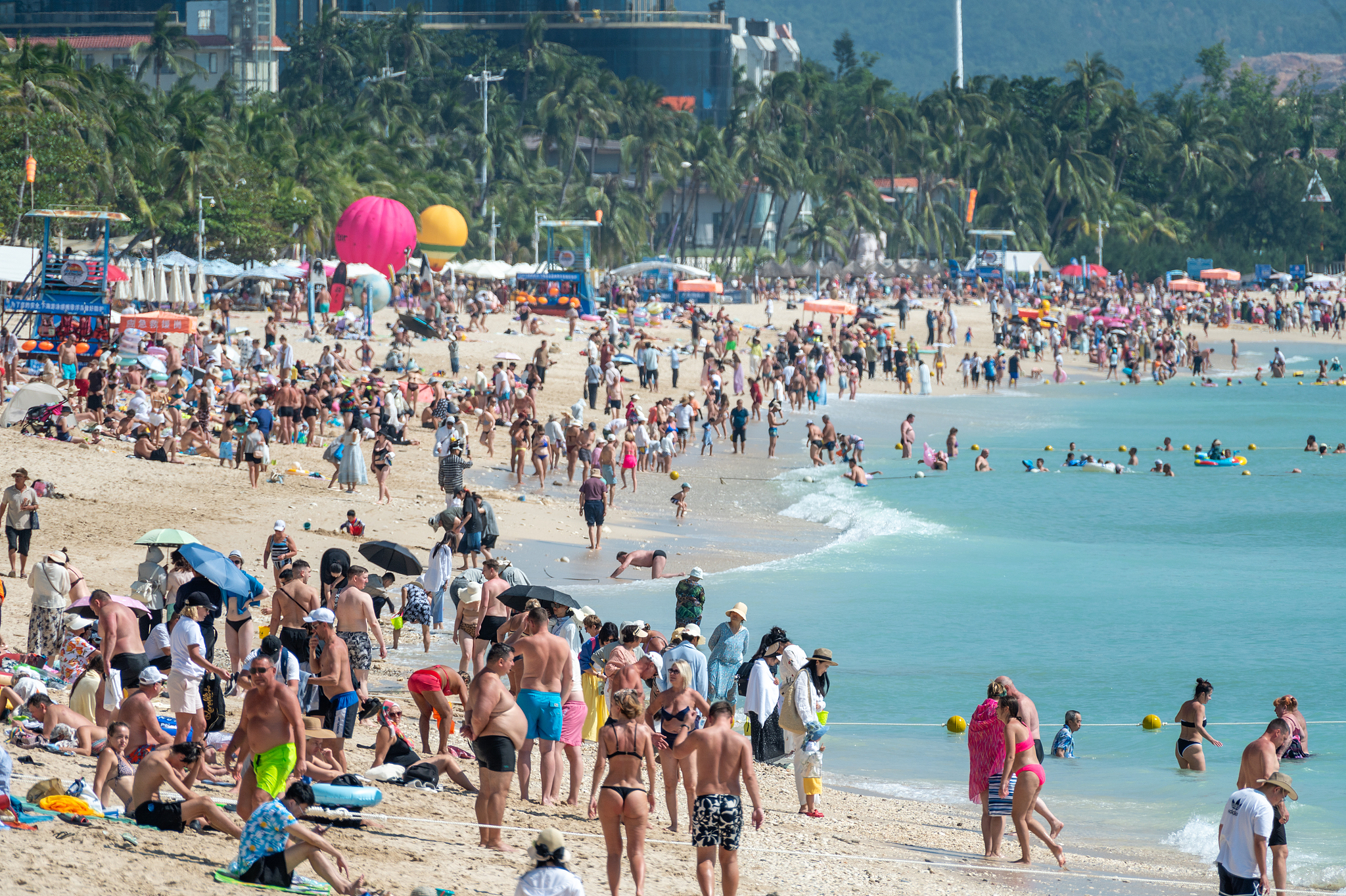 Visitors enjoy warm weather on a beach in Sanya, Hainan Province on November 26, 2025. /VCG