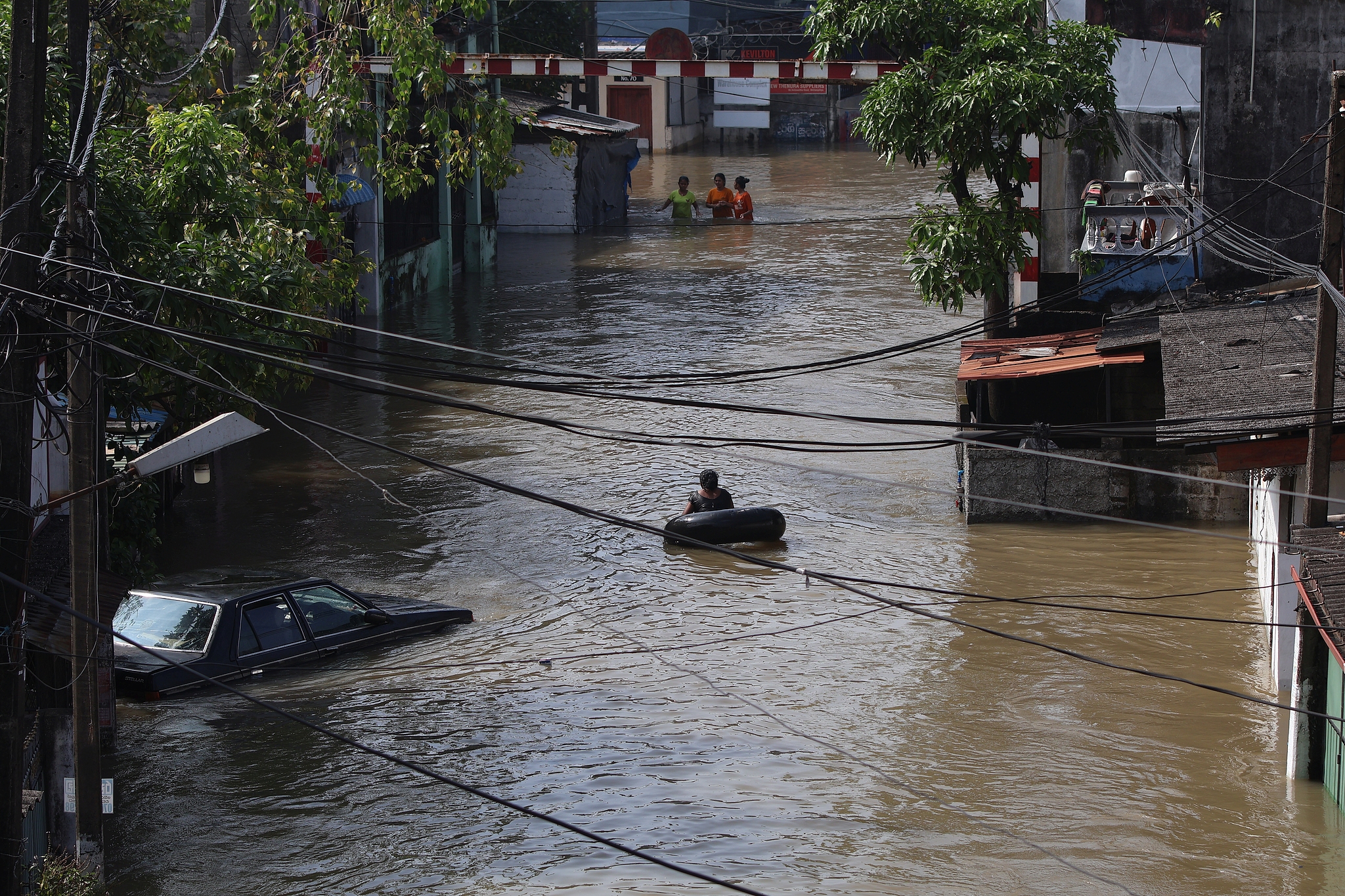 People wade through the flooded street in Colombo, Sri Lanka, December 1, 2025. /VCG