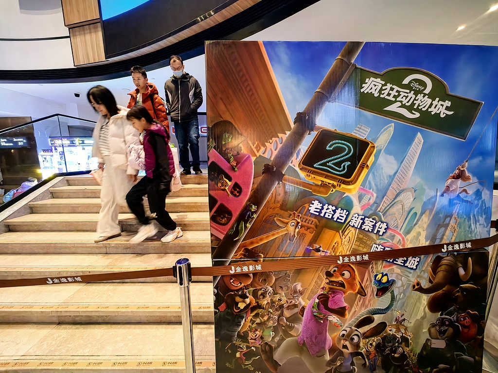 People are seen in a theater with a poster for Zootopia 2 displayed at the entrance, Beijing, China, December 2, 2025. /VCG