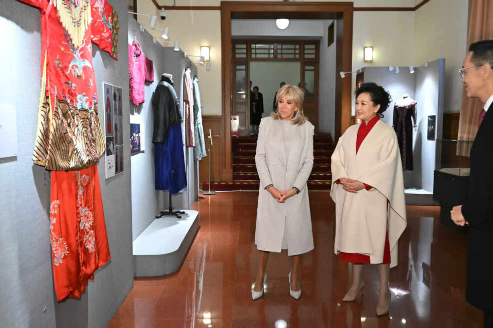 Peng Liyuan, wife of Chinese President Xi Jinping, and Brigitte Macron, wife of French President Emmanuel Macron, visit the Beijing People's Art Theatre (BPAT), Beijing, December 4, 2025. /China Media Group