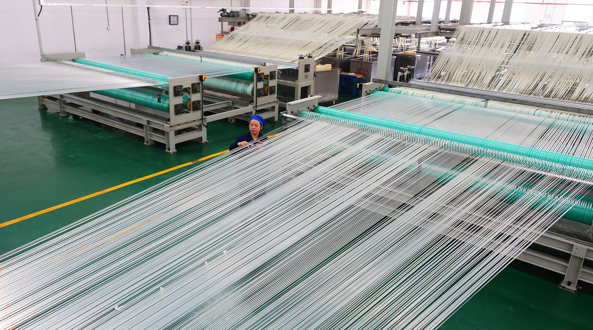 A worker sorts on a high-strength and high-modulus polyethylene fiber production line in Lianyungang, Jiangsu Province, Nov. 27, 2025. /VCG