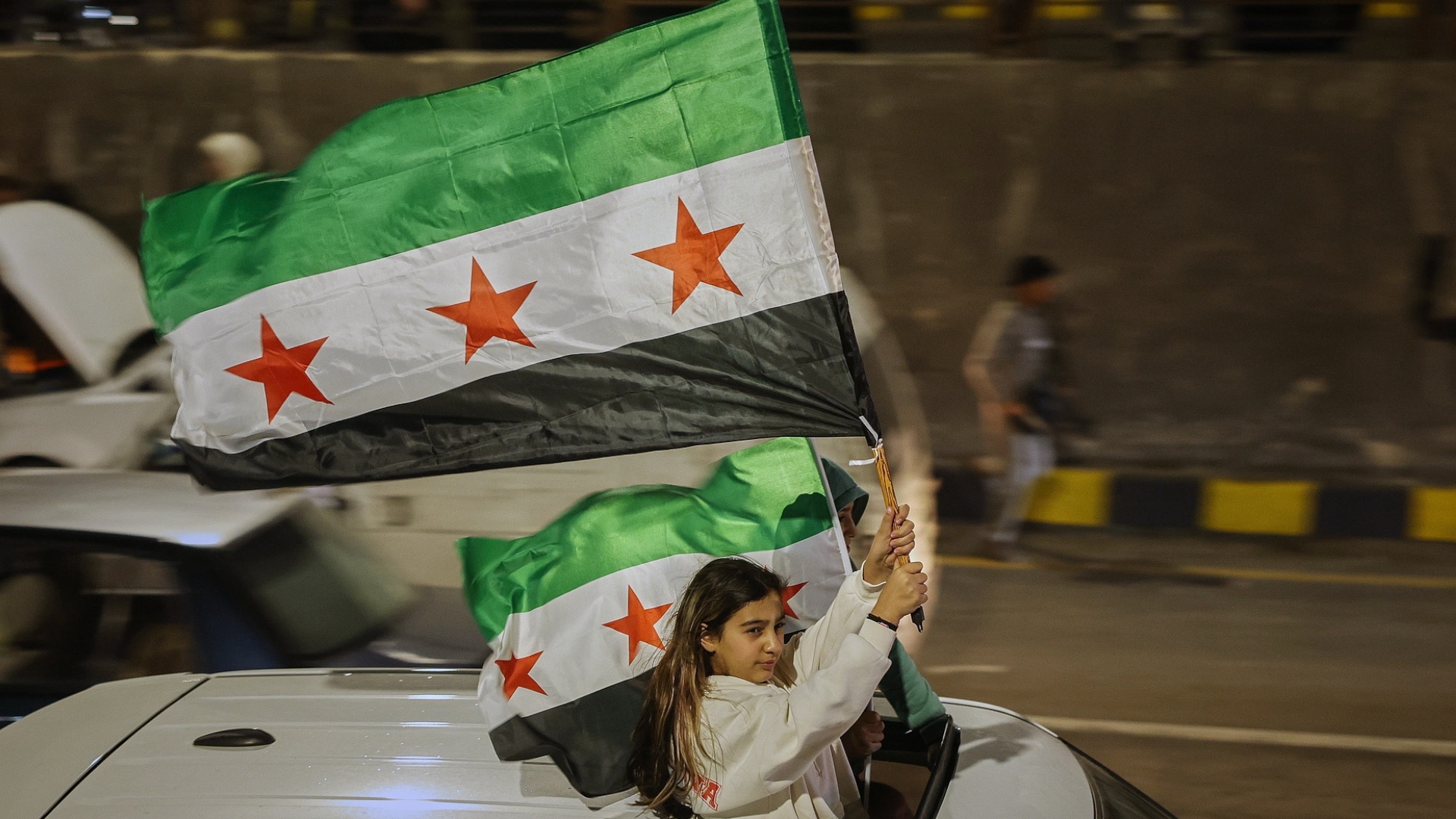 A girl holds a Syrian flag during celebrations marking the first anniversary of the fall of the Bashar al-Assad government in Damascus, Syria, on Friday, December 5, 2025. /VCG