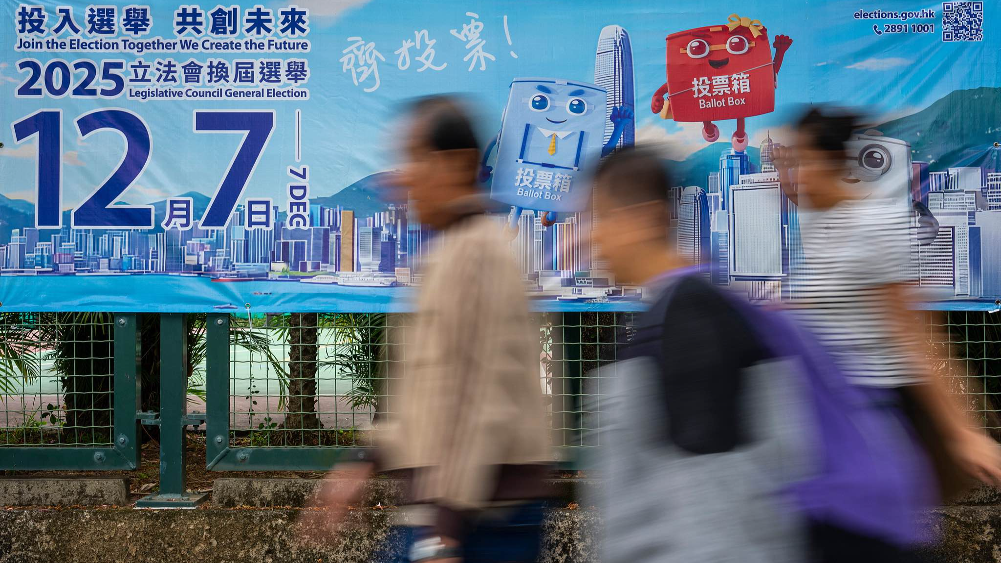 Pedestrians walk past banners promoting the Hong Kong Legislative Council General Election near the site of the fire at Wang Fuk Court in the Tai Po district of Hong Kong on Wednesday, December 3, 2025. /CFP