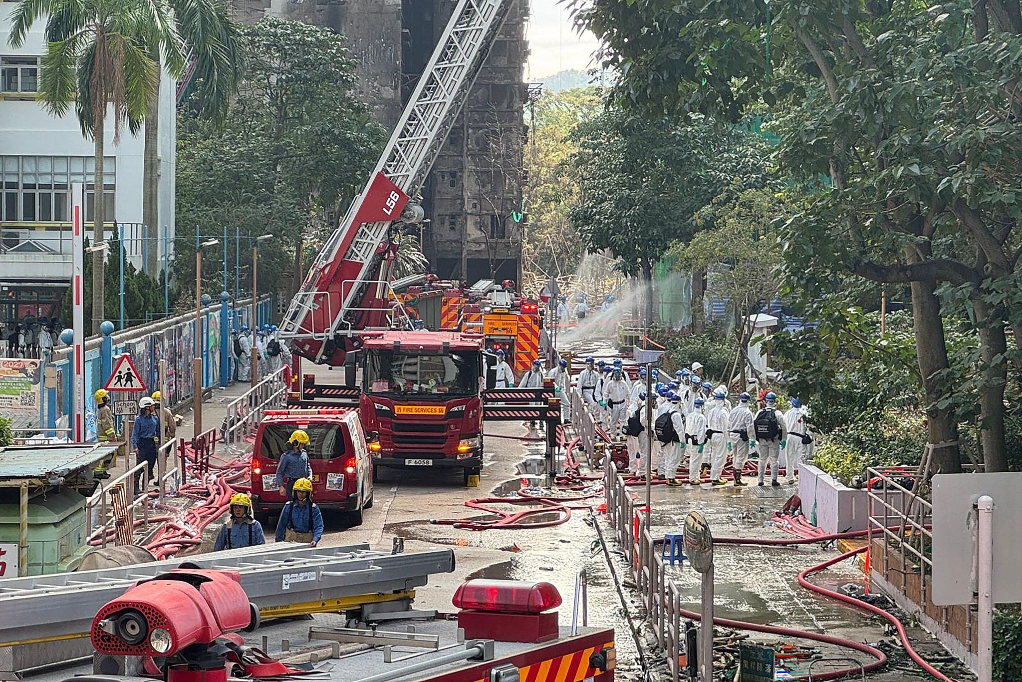 Police officers from the Disaster Victim Identification Unit enter one of the housing blocks of Wang Fuk Court housing complex in Tai Po, south China's Hong Kong, November 29, 2025. /VCG