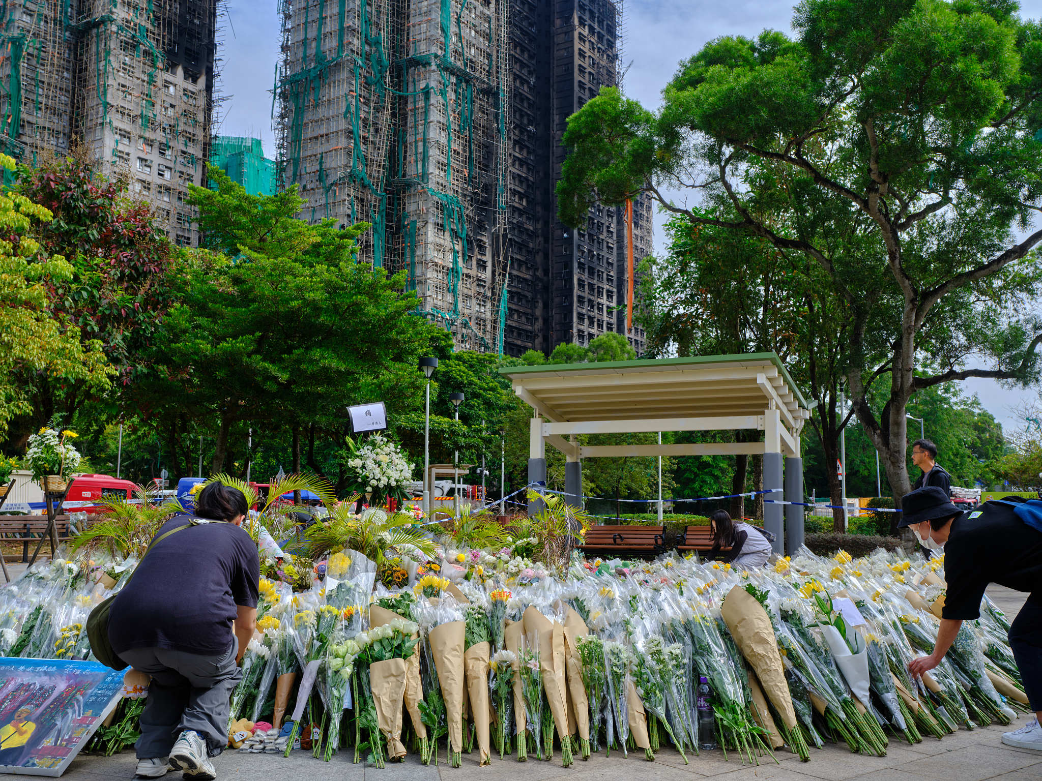 People lay flowers to mourn the victims of a blaze at Wang Fuk Court housing complex in Tai Po, south China's Hong Kong, December 1, 2025. /VCG