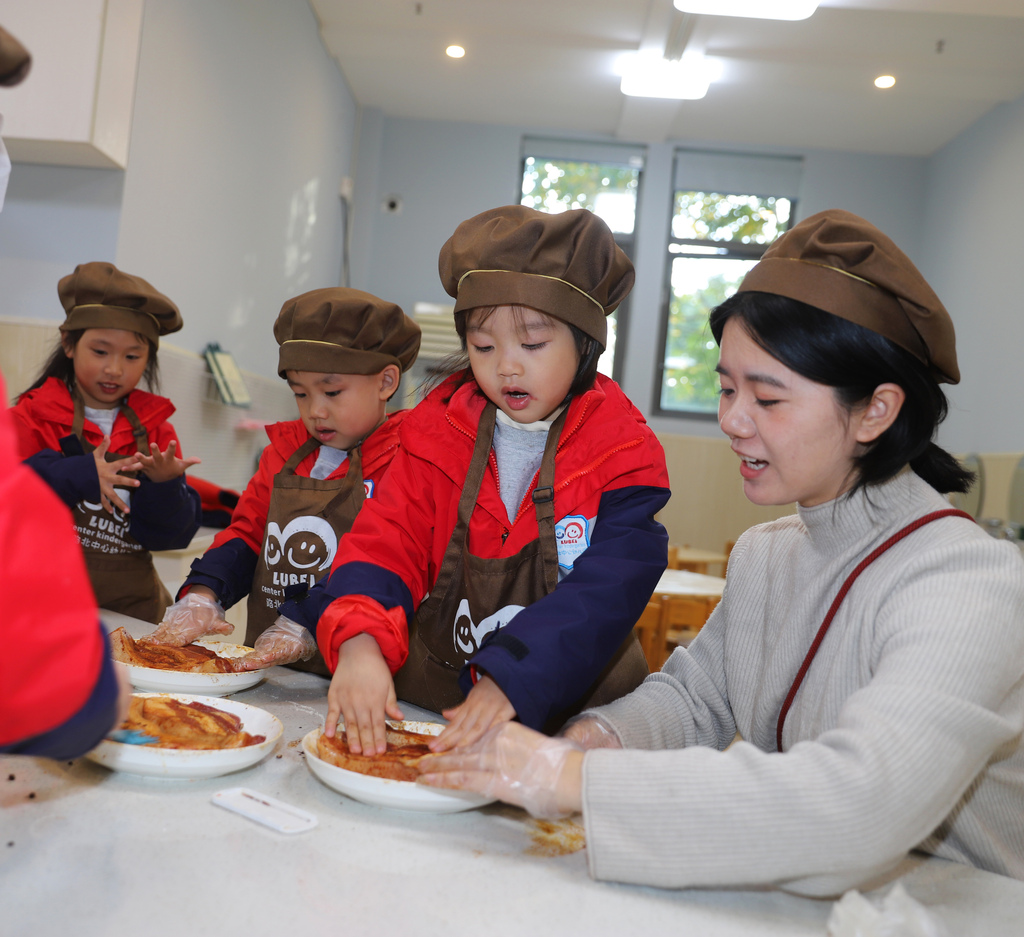 Children learn how to cure preserved pork at a kindergarten in Taizhou City, Jiangsu Province to mark the solar term of Major Snow. /VCG