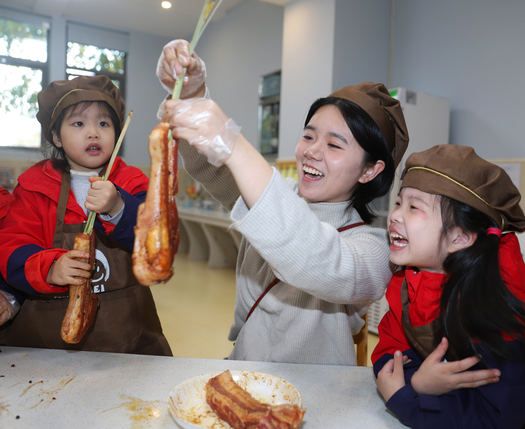Children learn how to cure preserved pork at a kindergarten in Taizhou City, Jiangsu Province to mark the solar term of Major Snow. /VCG
