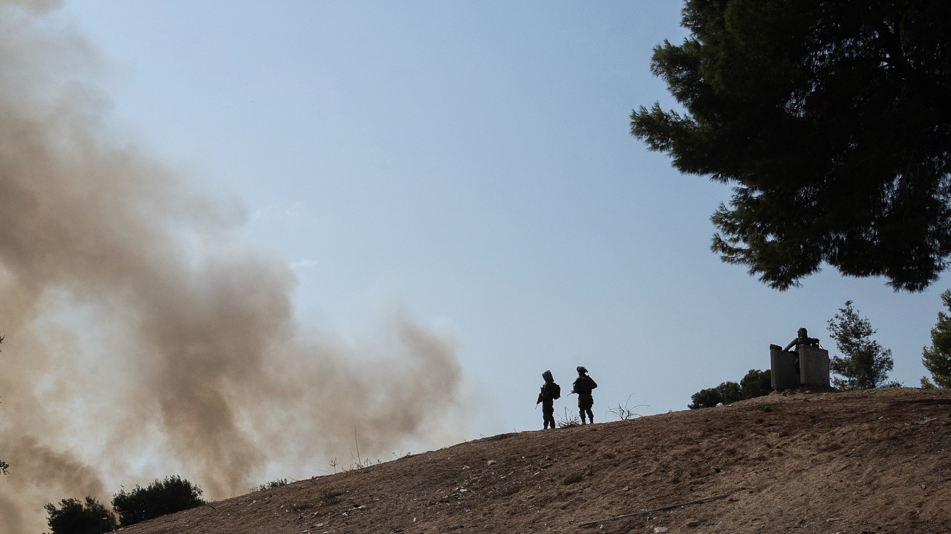A file photo of Israeli soldiers watching as a field burns after a rocket fired from Hamas landed outside a southern Israeli community near the Gaza border. /VCG