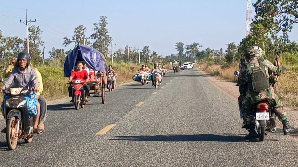 Cambodian soldiers (R) ride their motorbikes as local residents evacuate following clashes along the Cambodia-Thailand border in Preah Vihear province, December 8, 2025. /VCG