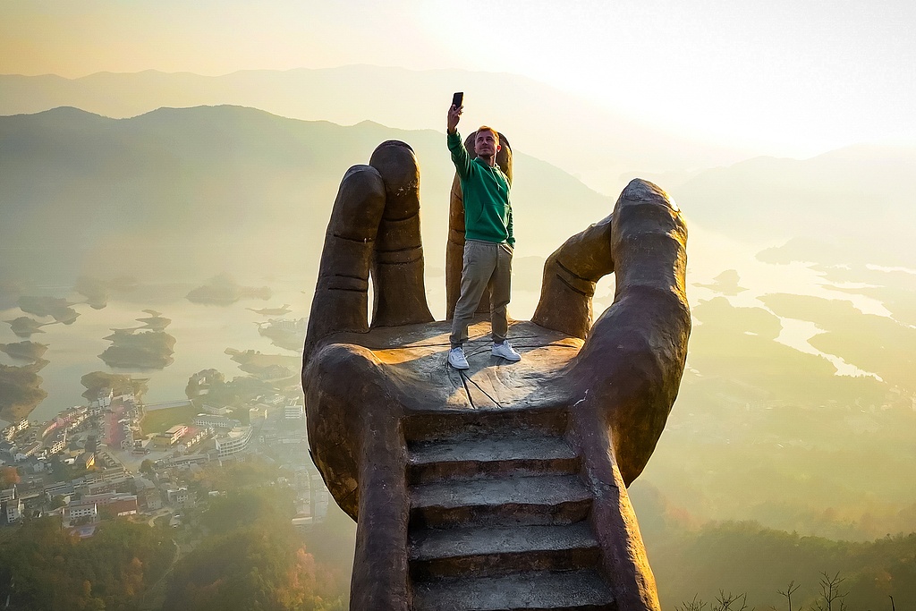 A tourist is seen on the Buddha's Hand in Yangxin County, Hubei Province on December 8, 2025. /VCG/Yuri Smityuk/TASS
