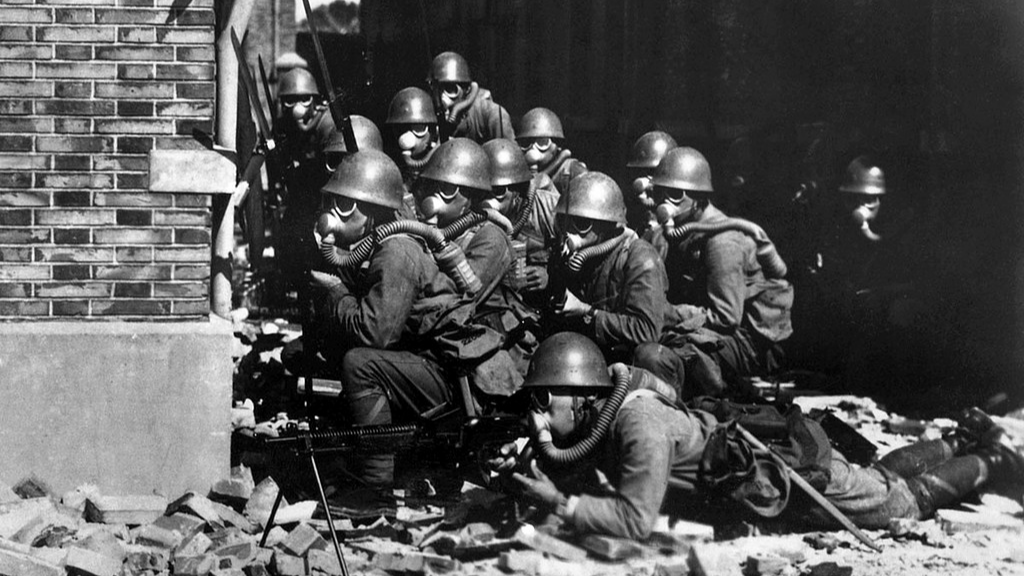 Photo features Japanese invaders with gas masks entering a battlefield in Shanghai in 1937. /VCG