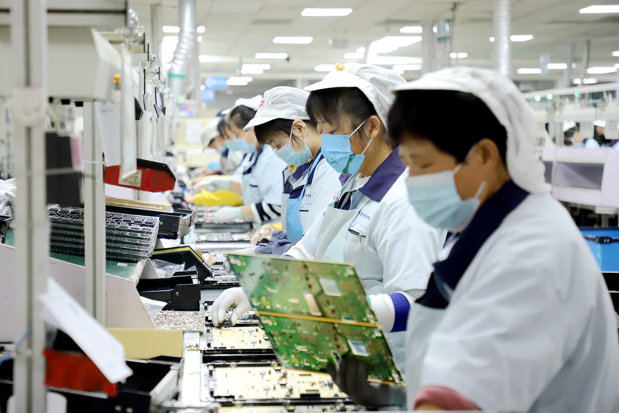 Workers were busy on the production line at a high-tech electronic products export company in Shandong Province, China. November 3, 2022. /VCG