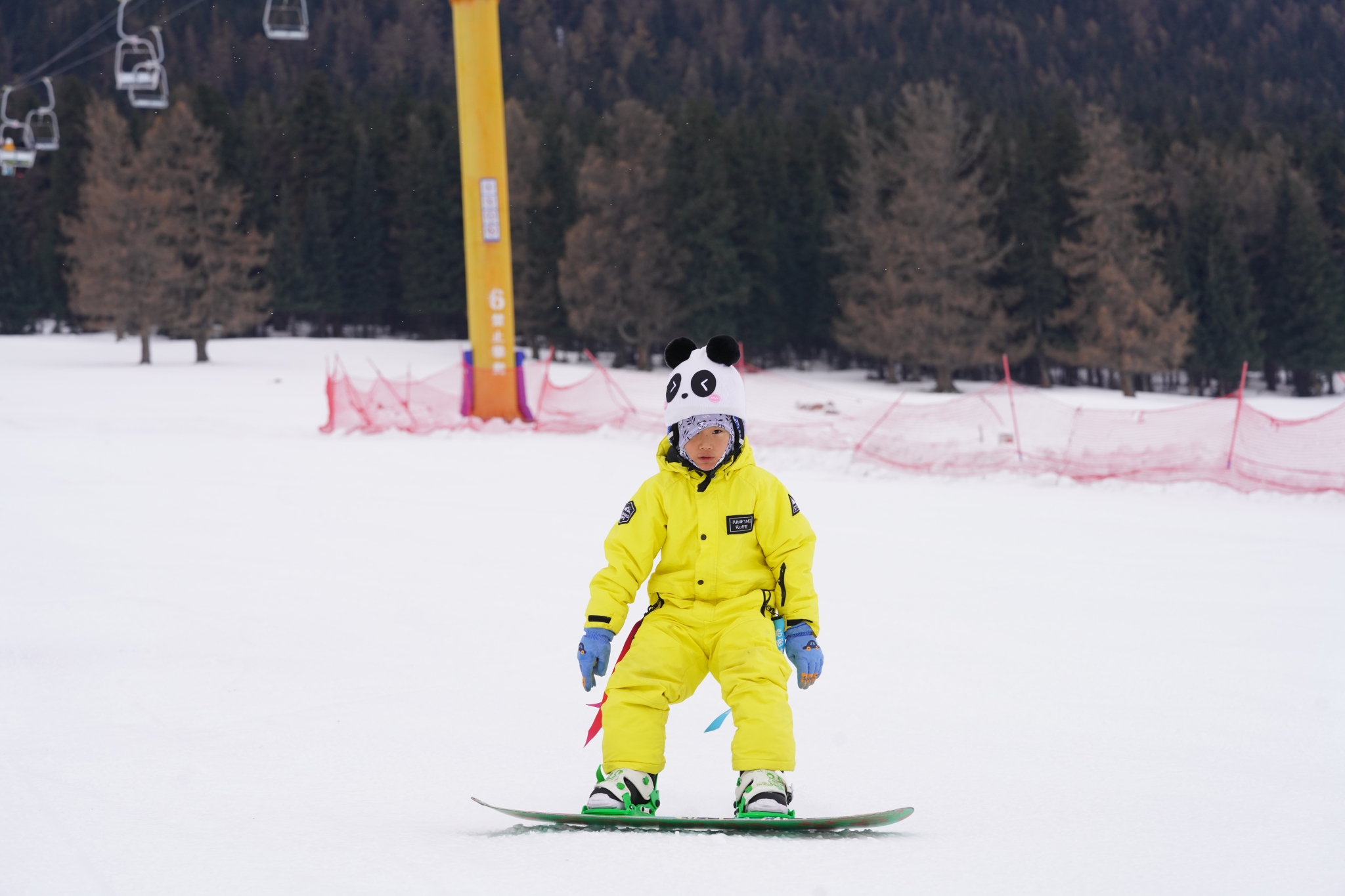 A child enjoys snowboarding at the Songshutang Ski Resort in Hami, northwest China's Xinjiang Uygur Autonomous Region, on December 6, 2025. /VCG