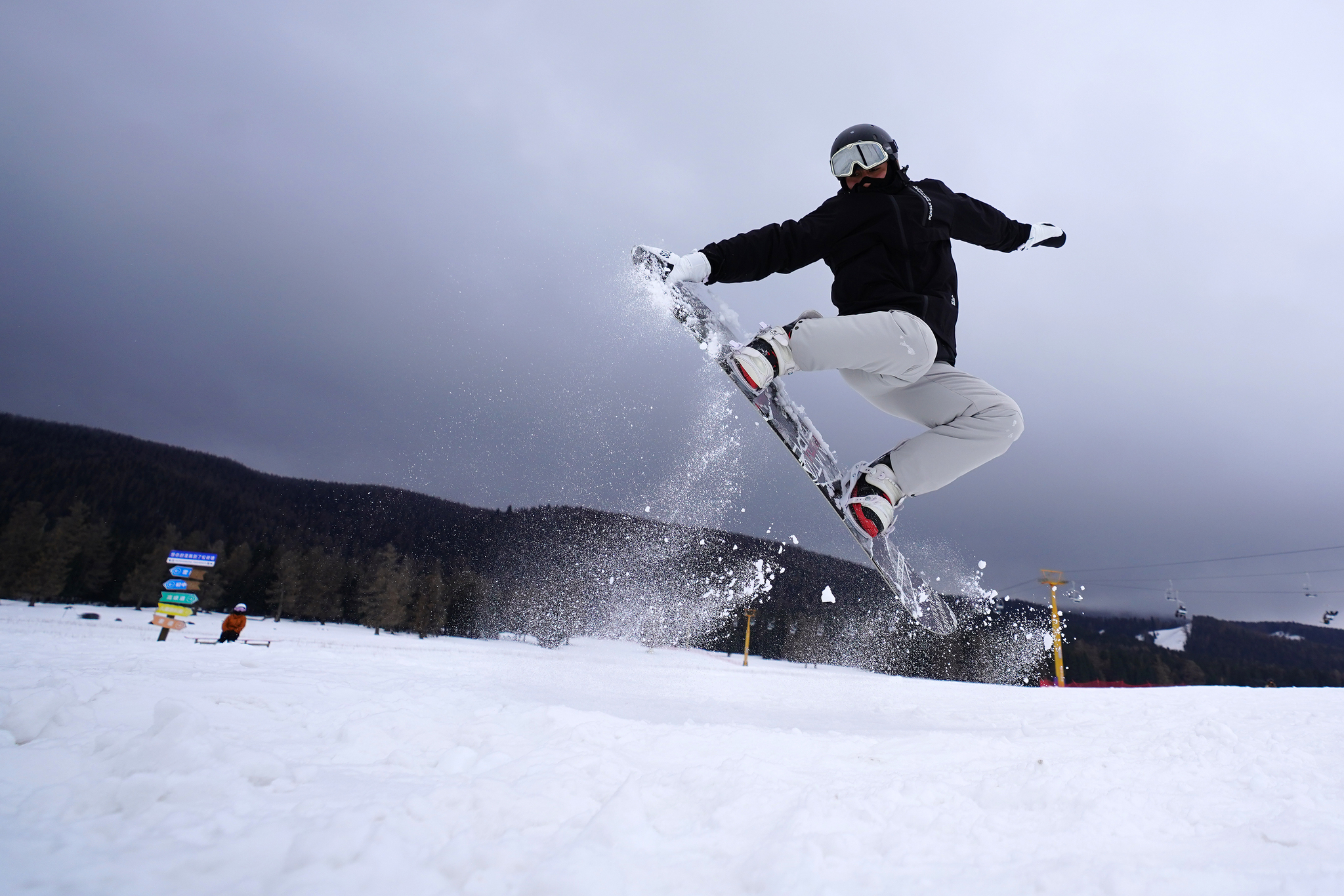 A visitor enjoys snowboarding at the Songshutang Ski Resort in Hami, northwest China's Xinjiang Uygur Autonomous Region, on December 6, 2025. /VCG