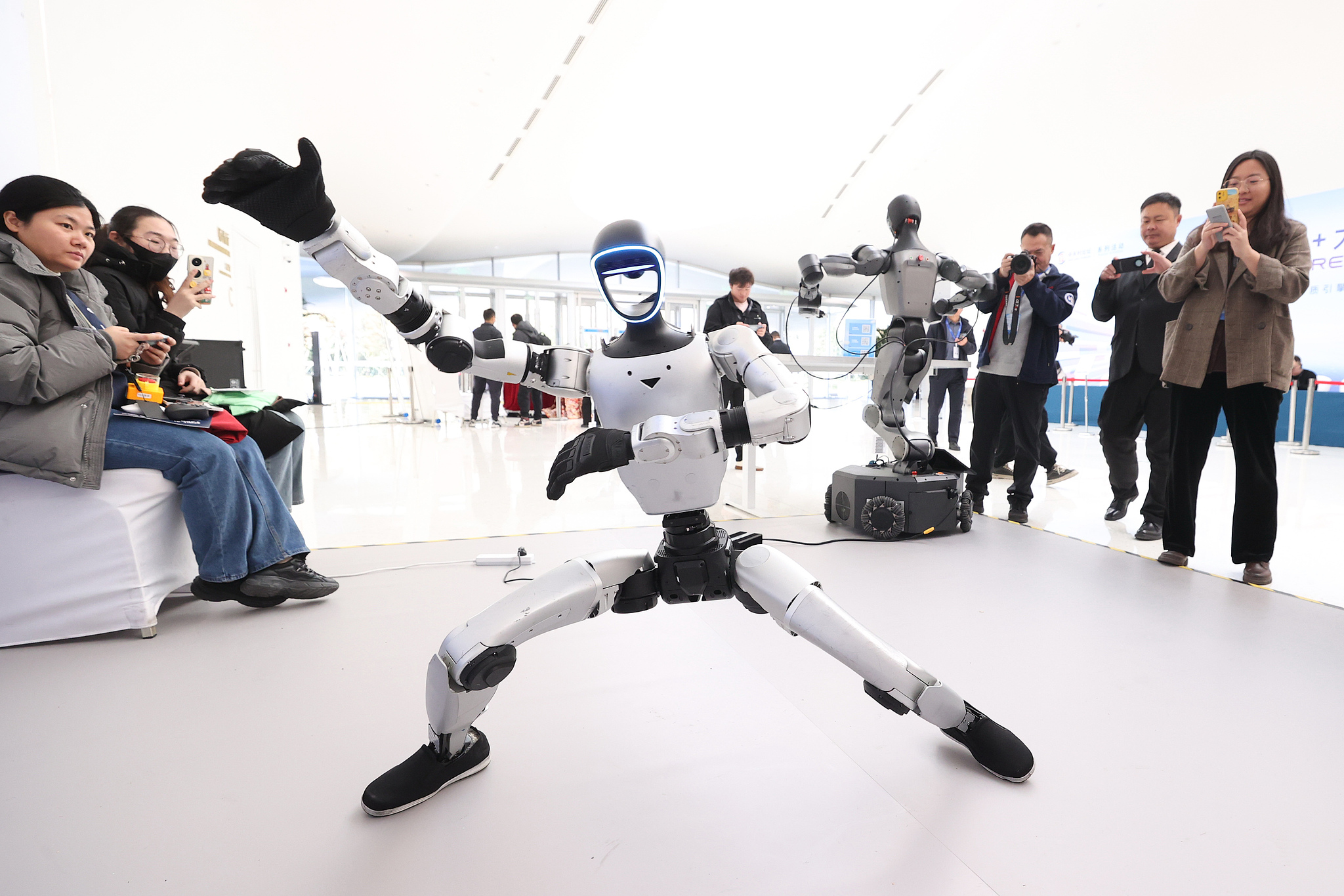 Participants watch a robot perform kung fu during the 2025 Global Artificial Intelligence + Conference in Beijing, November 16, 2025. /VCG