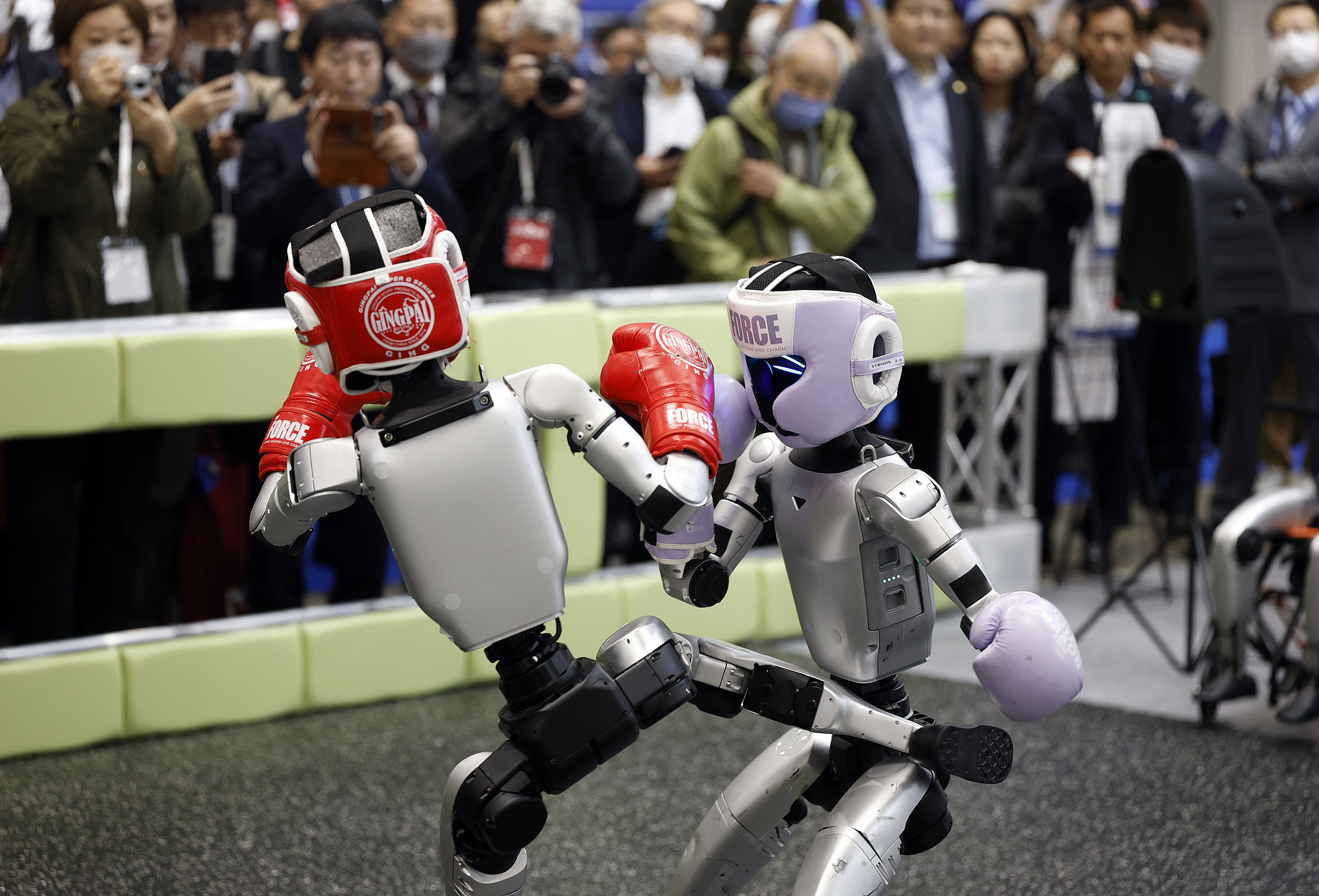 Unitree's humanoid robot G1 takes part in a boxing match at the TechShare booth of the 2025 International Robot Exhibition (iREX2025), December 3, 2025. /VCG