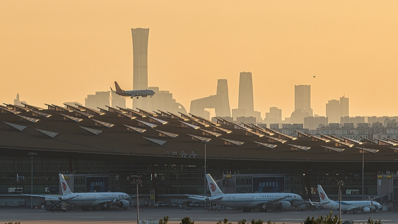 A plane takes off against the backdrop of the Guomao CBD from Beijing Capital International Airport in China, October 20, 2025. /VCG