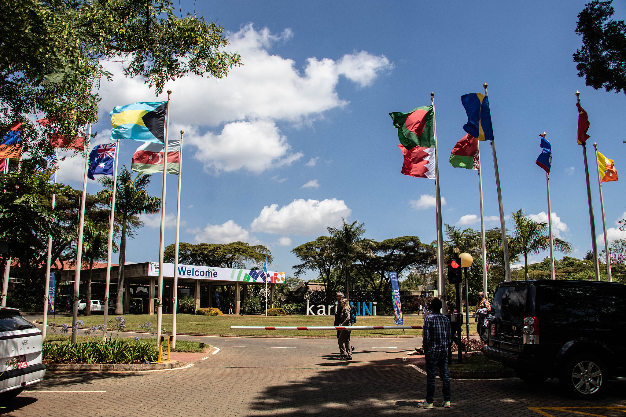 Delegates walk past UN member state flags during the UNEA-7 in Nairobi, Kenya, December 9, 2025. /VCG