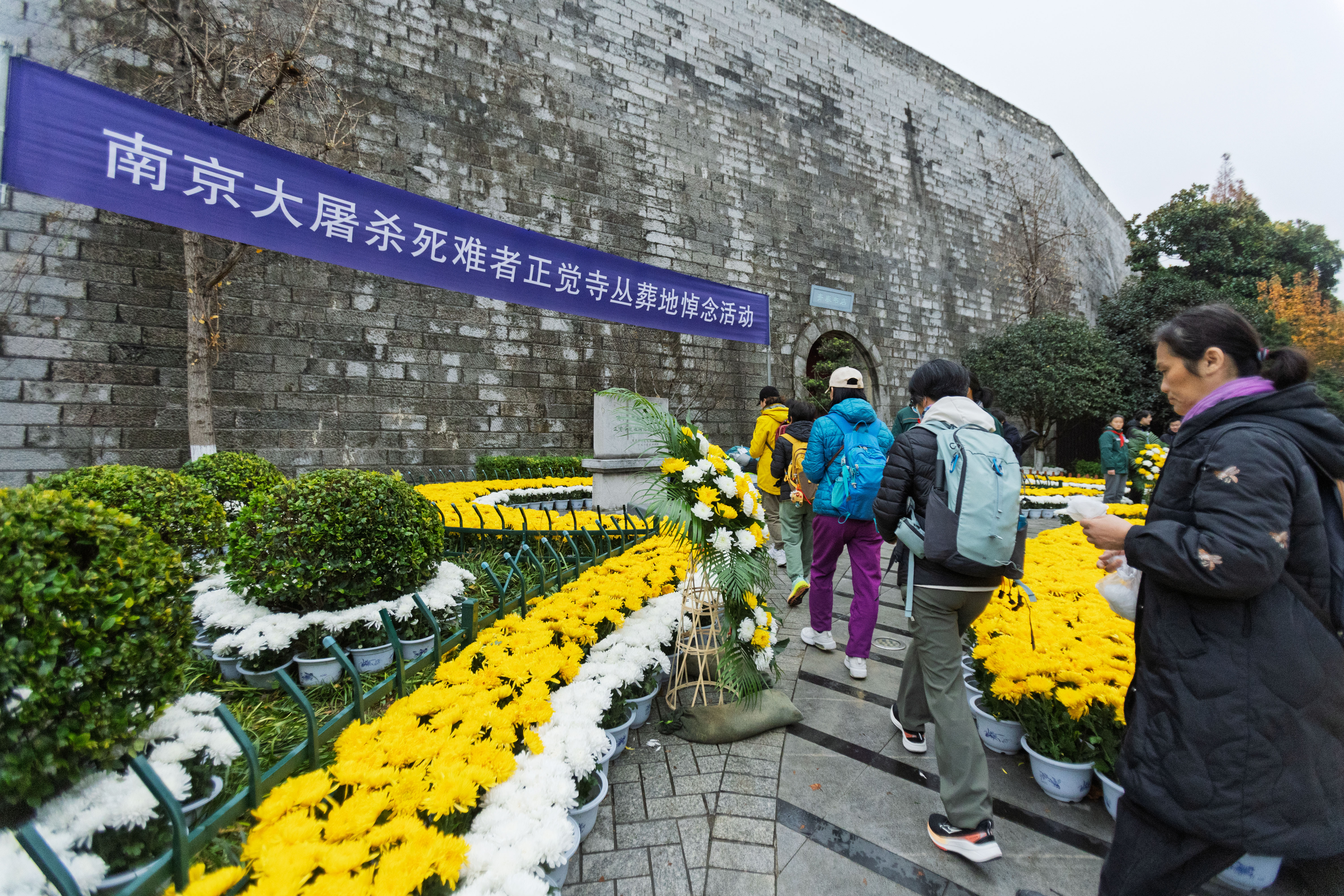 Residents pay tribute to the Nanjing Massacre victims at Zhengjue Temple beside the historical city wall in Nanjing on December 13, 2025. /IC