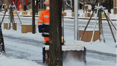 Staff uses a snow sweeper to clear snow on a street in Beijing, December 13, 2025. /CGTN