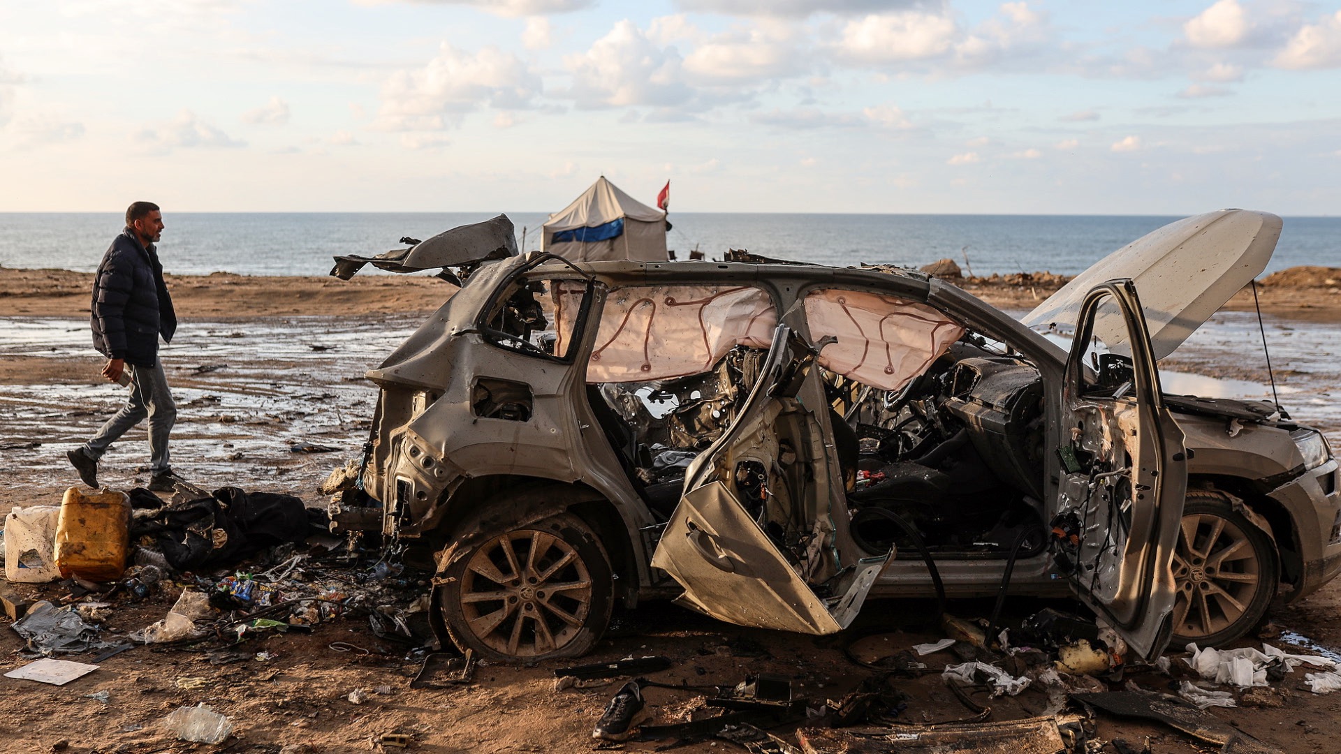 Palestinians inspect the remains of a vehicle destroyed in an Israeli military strike in Gaza City, Palestine, on December 13, 2025. /VCG