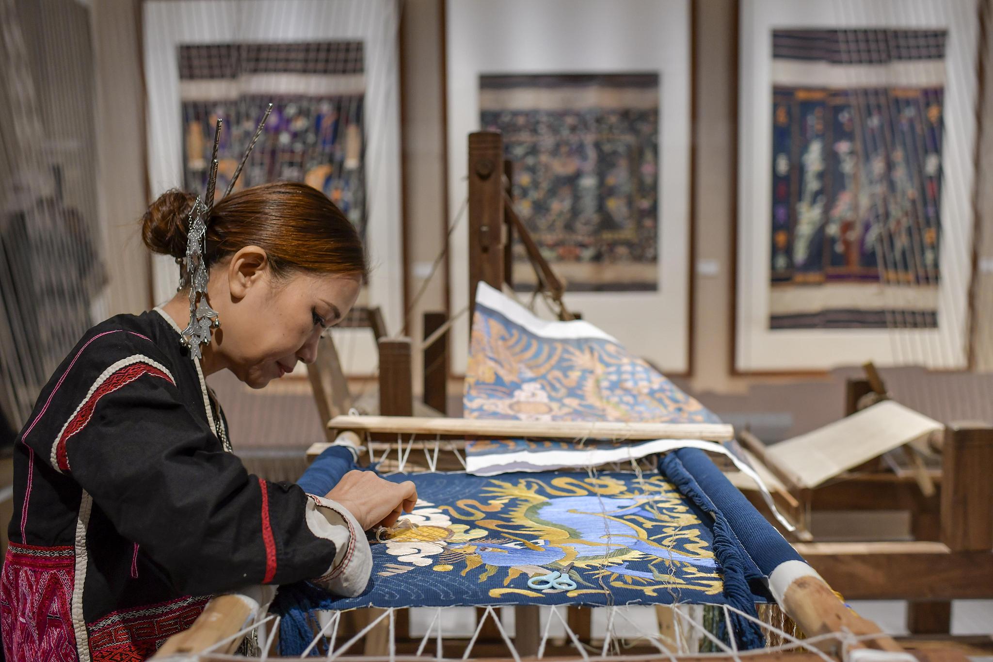 A woman works on Hainan Li ethnic brocade. /CFP